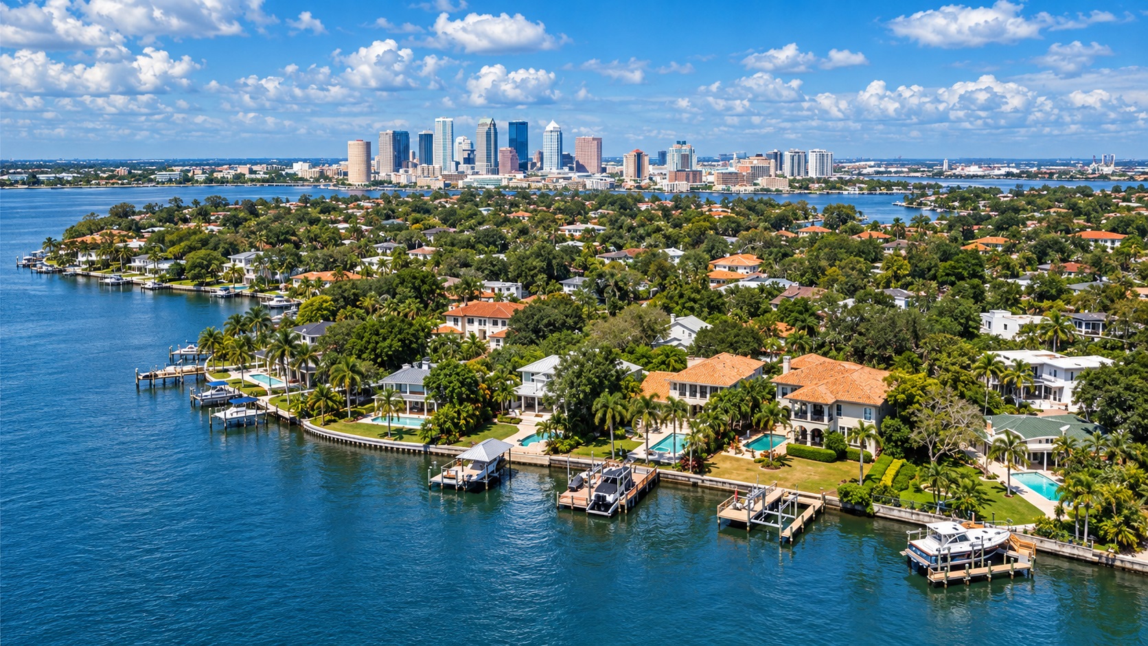 Aerial view of waterfront homes on Davis Islands with the Downtown Tampa skyline in the distance